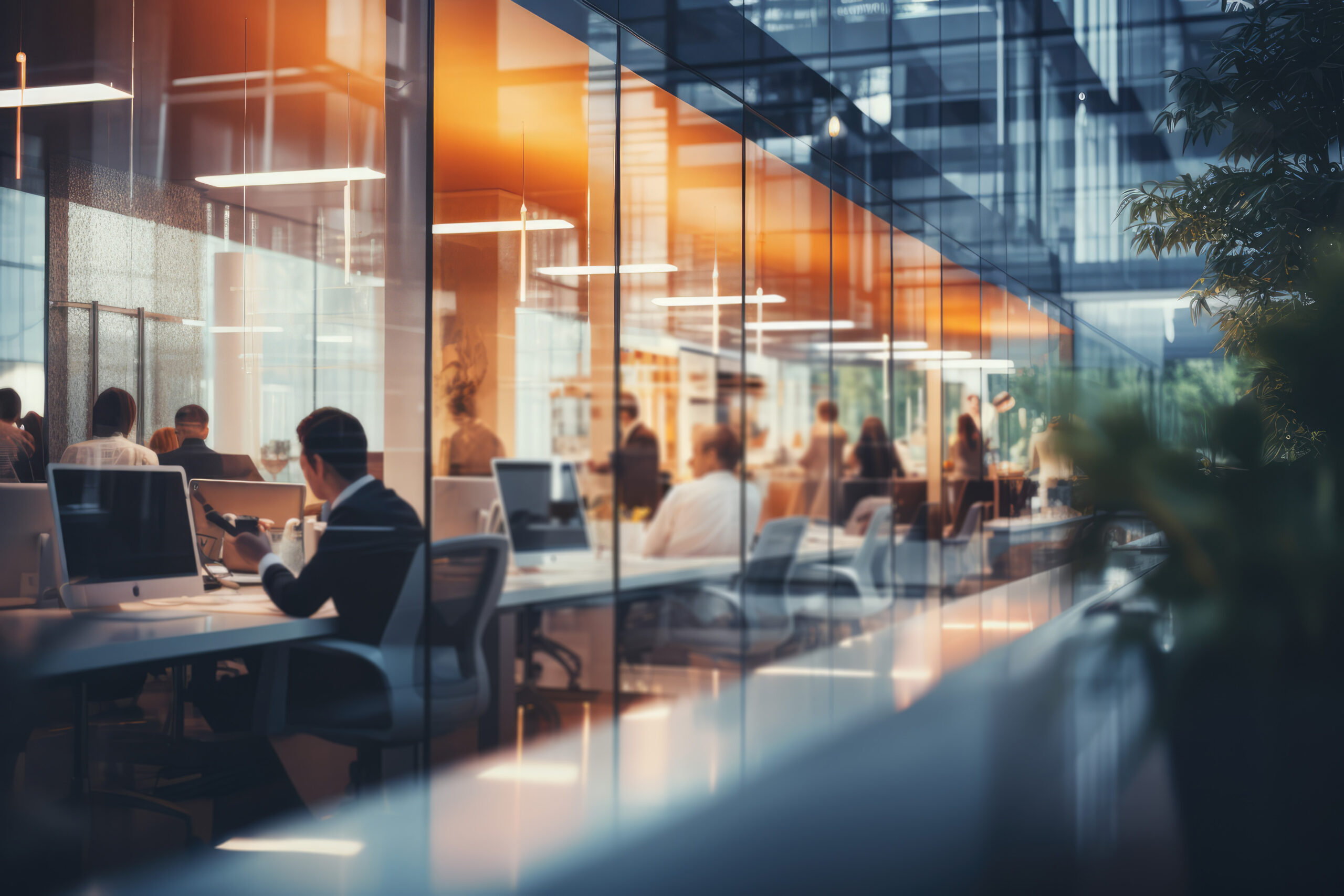 Unscharfes modernes Büro mit Mitarbeitern bei der Arbeit an gut ausgestatteten Arbeitsplätzen, die den modernen Technikanforderungen gewachsen sind